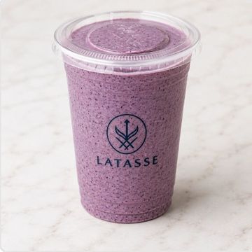 Purple smoothie in a plastic cup with LATASSE logo.