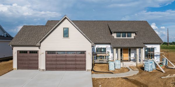 New house under construction with a large garage and unfinished exterior.