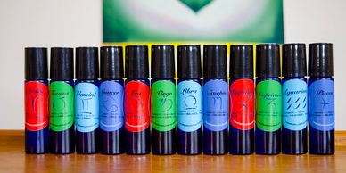 A row of colorful essential oil bottles with various labels.