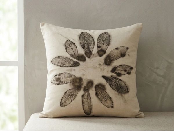 Decorative pillow with leaf print arranged in a circular pattern.