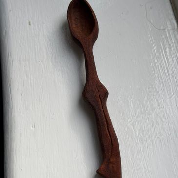Hand-carved wooden spoon with a dark finish.
