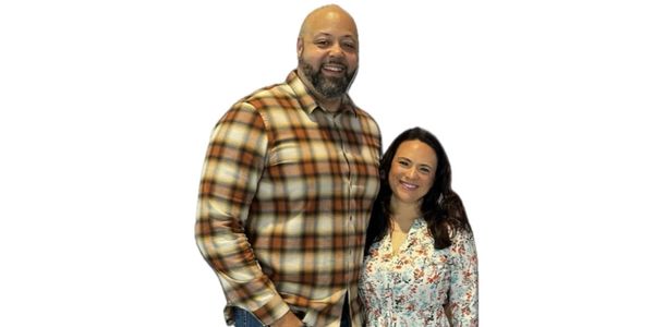 A happy couple posing together, smiling warmly.