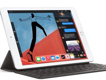 Tablet with keyboard case displaying messaging and artwork apps.