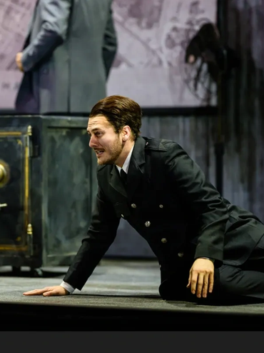 Actor in distress on stage during a dramatic performance.