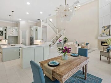 Bright open-concept kitchen and living area with blue accents and natural wood table.