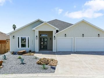 Modern single-story house with a triple garage and xeriscaped front yard.