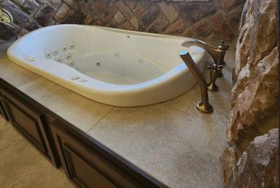 Soaking tub, tiled deck and custom wood panels that double as access panels. 