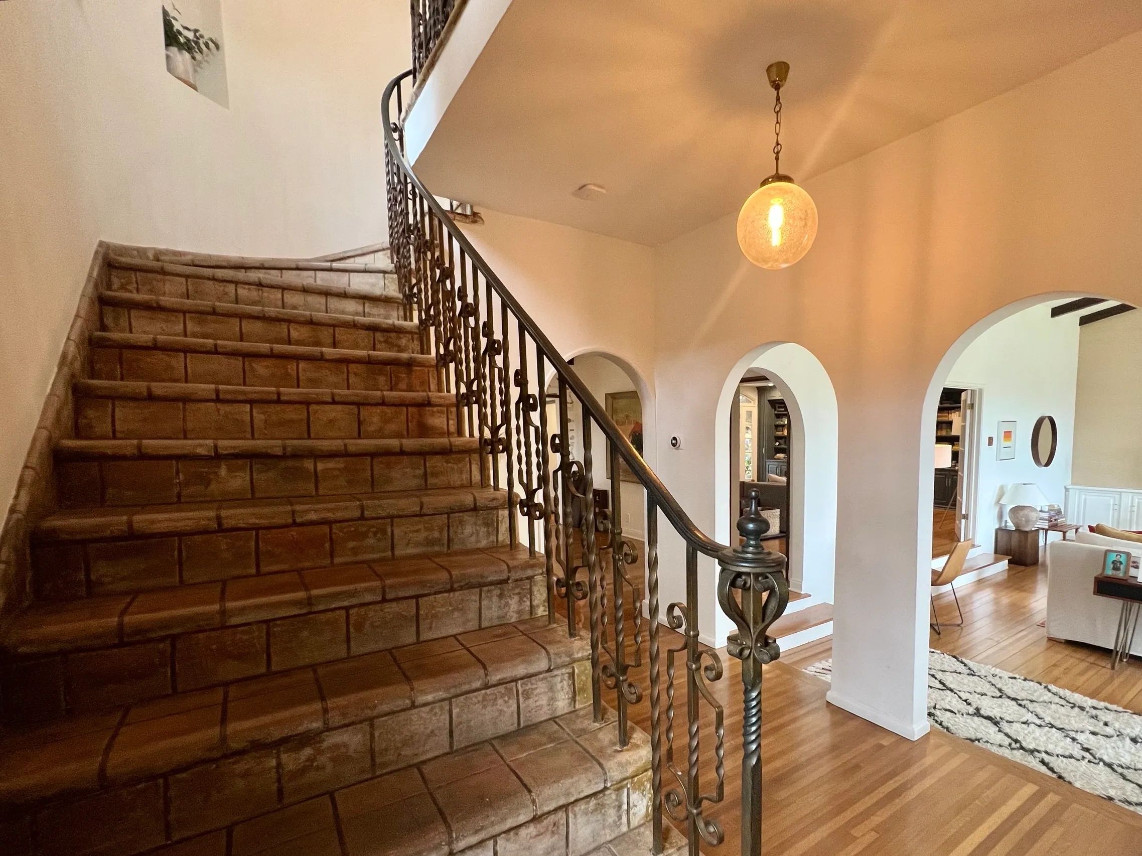 Beautiful home interior with curved tile stairs, and arched entrances to stylish living room.