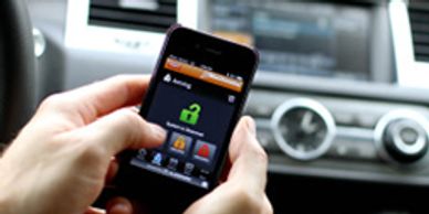 Person using a smartphone car control app inside a vehicle.