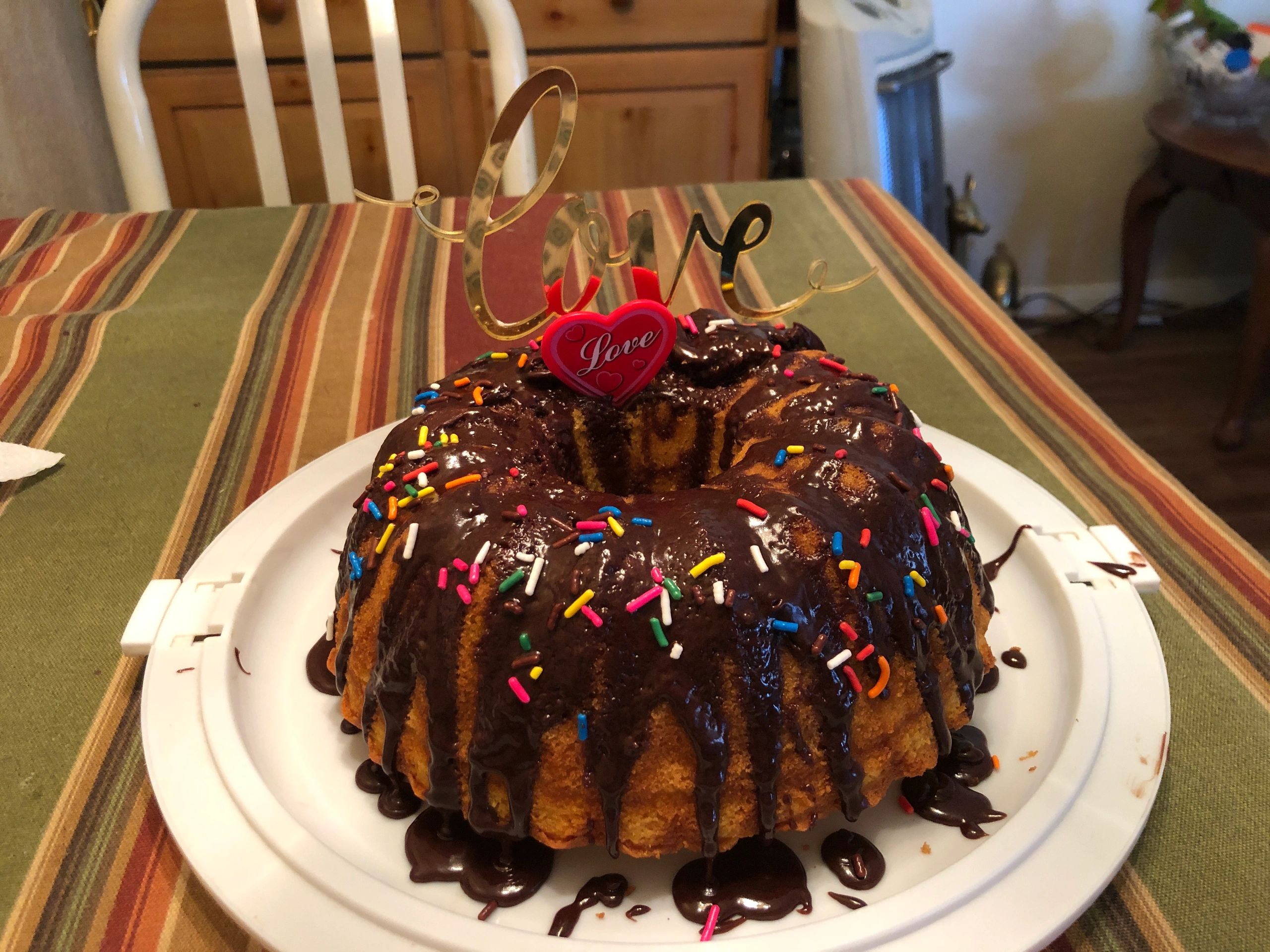 Chocolate glazed bundt cake with colorful sprinkles and love decorations.