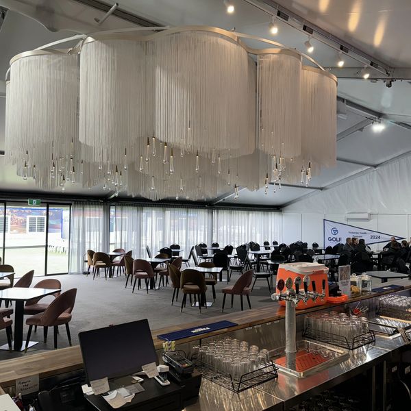 Spacious indoor dining area with modern chandelier and bar counter.
