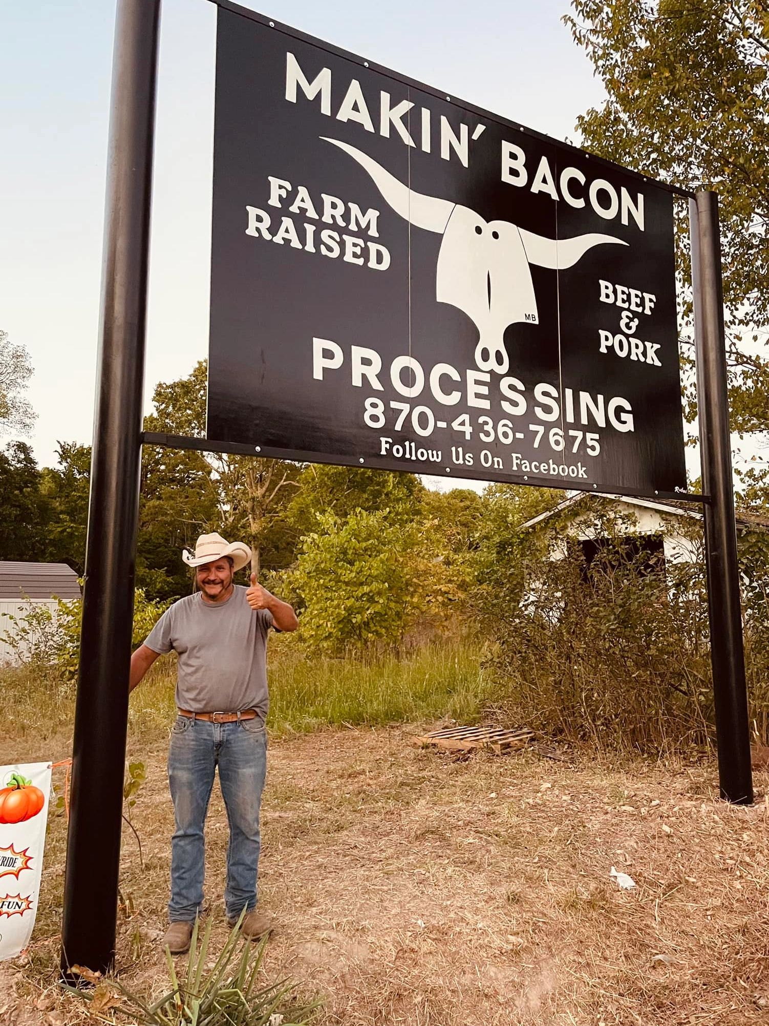 The Makin' Bacon sign at the side of the road at the entrance to the facility.