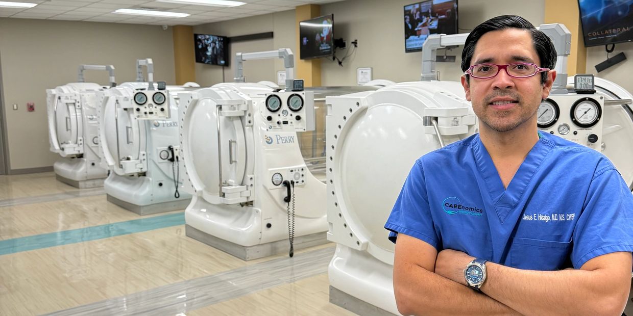 Dr. Jesús Hidalgo standing in the Carenomics hyperbaric unit surrounded by oxygen therapy chambers.