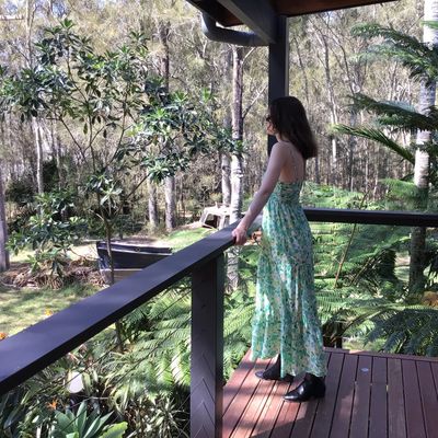 A young woman relaxes and enjoys the view from a balcony.