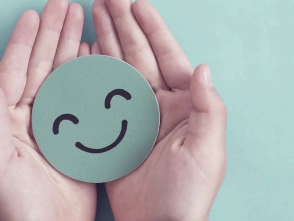 Green smiley face in hands