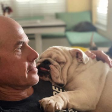 A man and his dog are looking at each other.