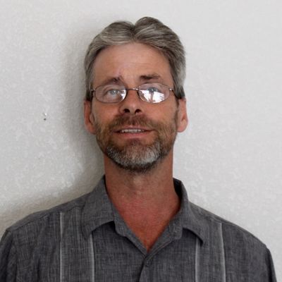 Middle-aged man with glasses and gray hair.