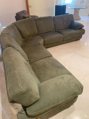 Large olive green sectional sofa in a bright room.