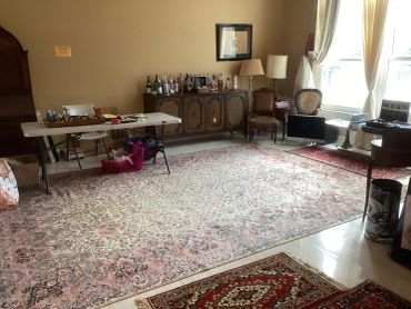 Living room with vintage furniture and rugs.