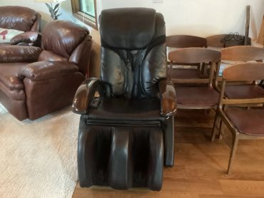 Black leather massage chair in a living room.