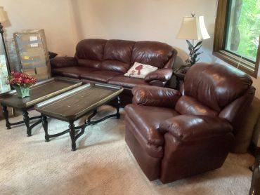 Brown leather sofa set with coffee tables in a cozy living room.