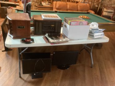 Table with vintage radios and vinyl records beside a pool table.