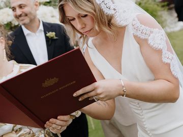 A bride signing the paperwork at her wedding. 