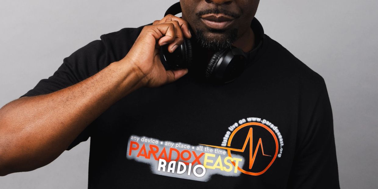 Man wearing black Paradox East Radio t-shirt with headphones.