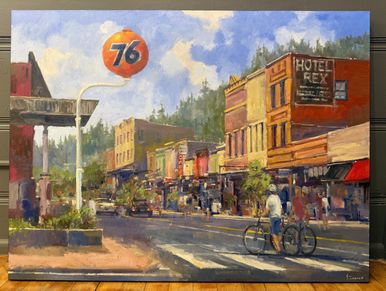 A vintage town street scene with a 76 gas station sign and a cyclist.