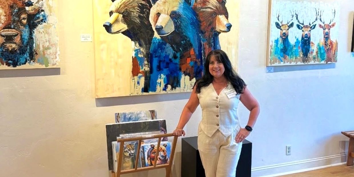 Woman posing in front of colorful animal paintings in an art gallery.