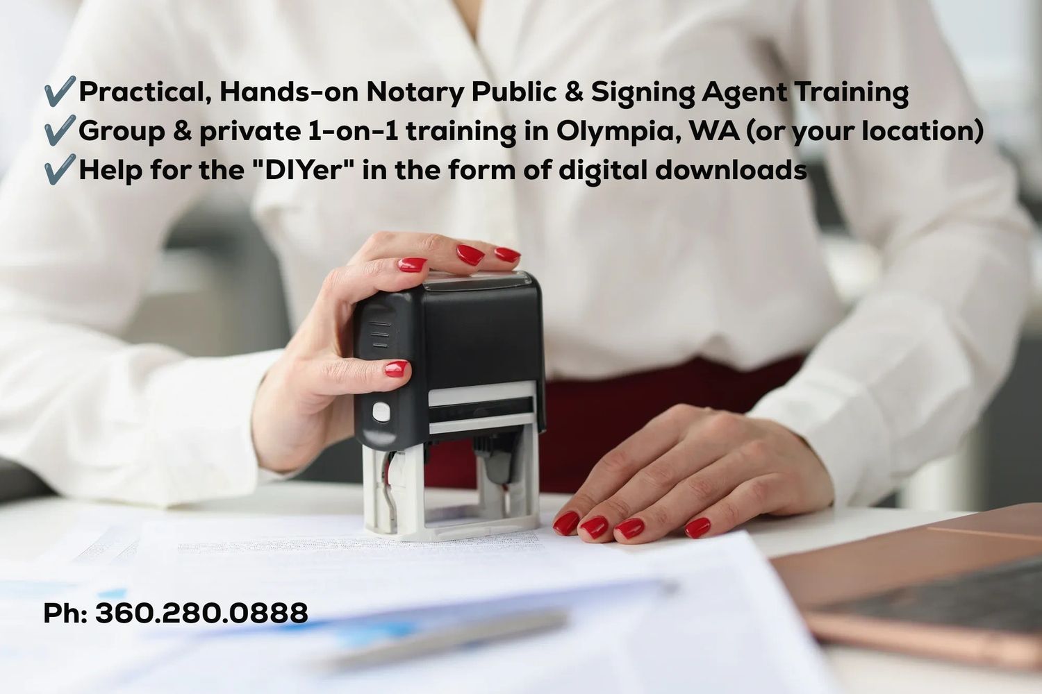 Person stamping documents with a black stamp on a desk.