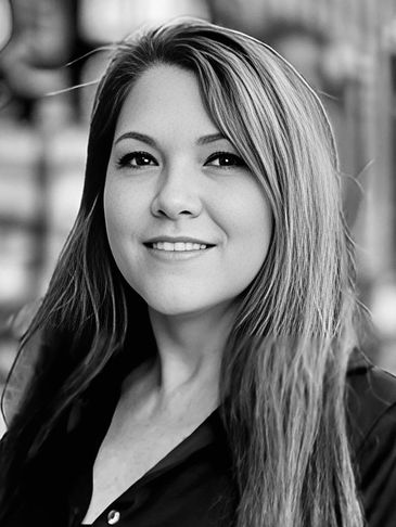 Black and white portrait of a smiling young woman with long hair.