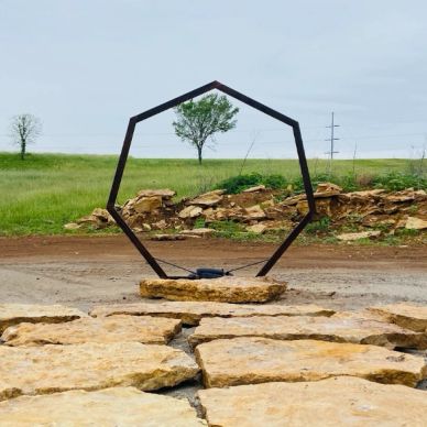 Octagonal metal frame art installed outdoors.