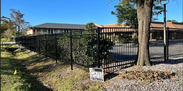 Black metal fence around a property under a clear sky.