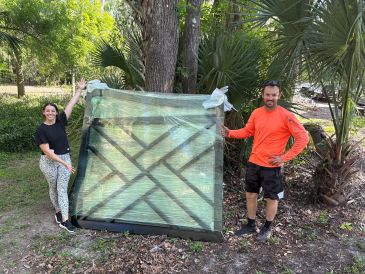 Two people holding a wrapped gate