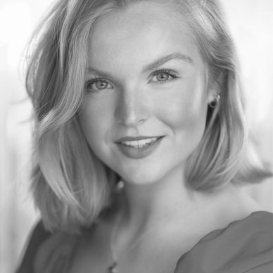 Black and white portrait of a smiling woman with shoulder-length hair.