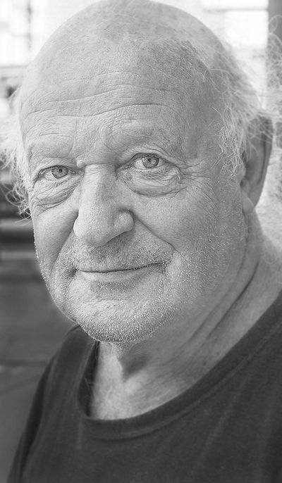 Portrait of an elderly man with a gentle smile and light blue eyes.