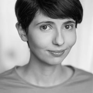 Portrait of a young person with short brown hair and a soft smile.