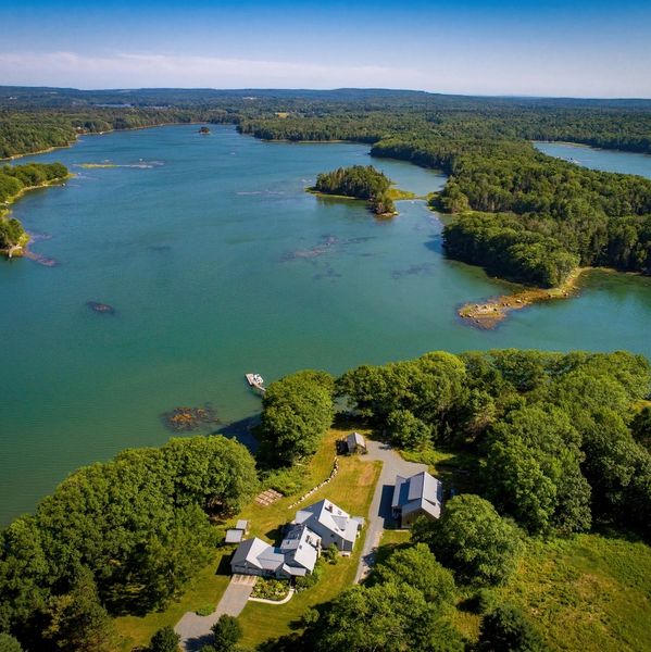 A serene waterfront property surrounded by lush greenery and calm waters.