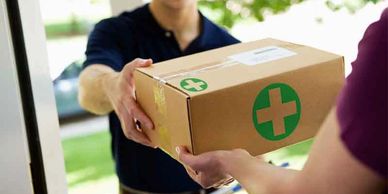Person handing over a first aid kit box to another person.