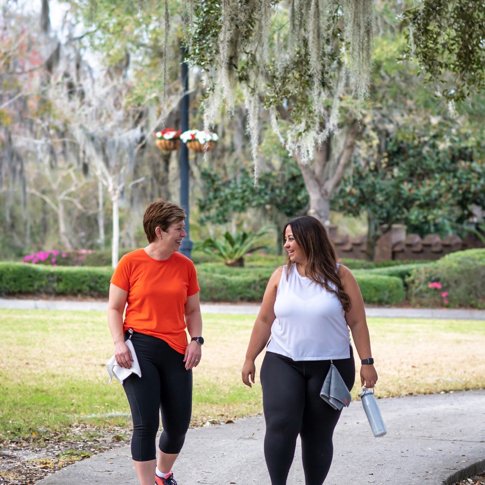 Two women walking and laughing wearing Dry in Stride retractable towels. 