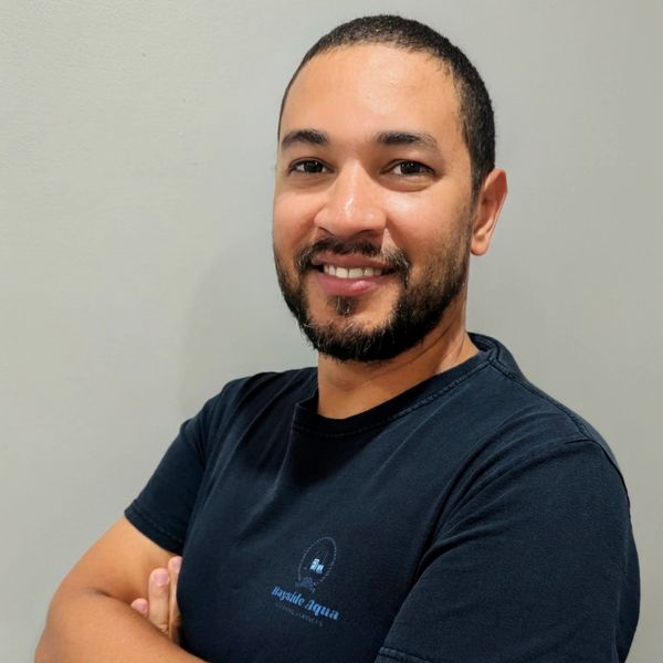 Smiling man with folded arms in a black t-shirt.