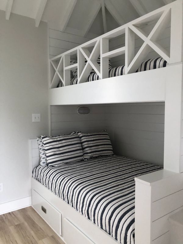 Cozy bunk bed with striped bedding and built-in storage.