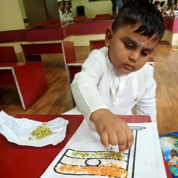 Child placing seeds on a drawing in a classroom.