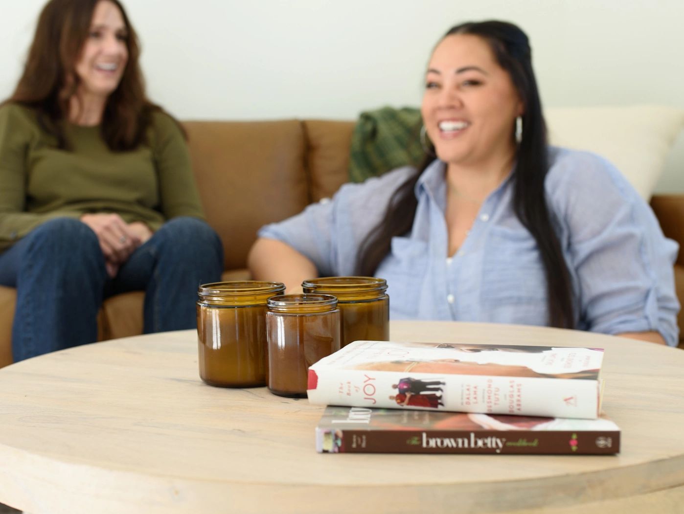 Photo of owner of Lite Brite Candles in living room with amber candle jars