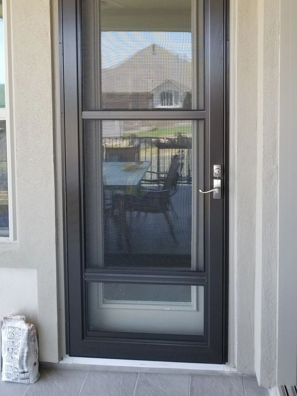 Bronze glass operator storm door (glass and screen combo), hinge left, with satin nickel handle and deadbolt
