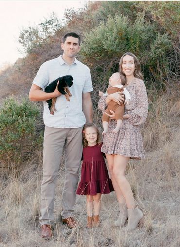 Family picture with black and tan Cavalier puppy