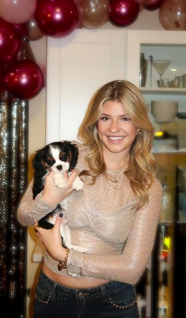 Attractive lady holding Cavalier King Charles Spaniel puppy