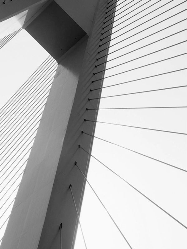 Black and white abstract photo of a bridge's cable-stayed tower.