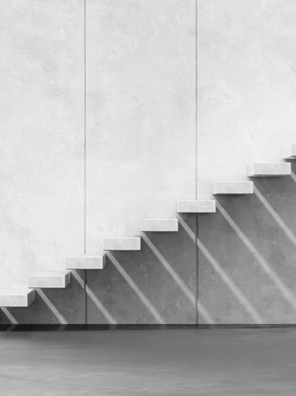 Minimalist floating concrete stairs casting shadows.